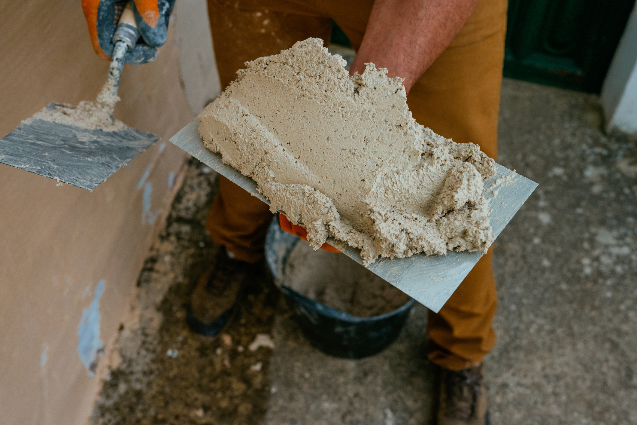 Mason Applying Mortar To A Wall During Renovation Work